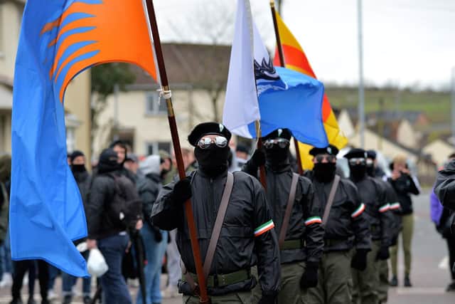 Masked men in military style uniforms take part in a republican Easter Commemoration march in Creggan on Monday afternoon. Photo: George Sweeney