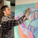 Artist Adrian Margey painting Dunluce Castle.