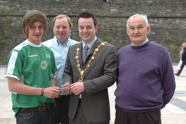 Gerry 'Doc' Doherty, Foyle Harps President, on right, with the Mayor of Derry, Councillor Colum Eastwood in 2011, as he presented Ben McFadden, captain, Foyle Harps U-15 squad with a commemorative plaque at a reception at Derry's Guildhall held to mark their winning of the National League trophy, the Scotland cup, the Derry journal Cup, Rocara cup and Rambo Gillespie cup. Also included is John Shiels, coach.