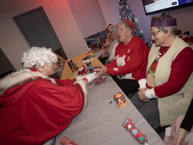 Mrs. Claus handing out gifts to those in attendance at last week's Christmas Party in the Catheral Youth Club.
