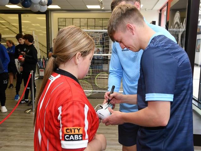 Derry City vice captain Ciaron Harkin signs his autograph for a young fan at the O'Neills store.