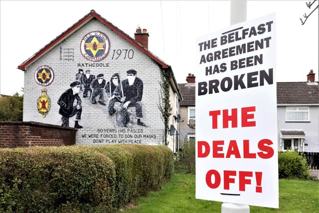 2021: A sign claiming the Belfast (Good Friday) Agreement had been broken by the Northern Ireland protocol in Britain's Brexit deal erected beside a mural of masked members of the loyalist paramilitary group, the Red Hand Commandos in the Rathcoole estate, Newtownabbey, Co Antrim. PICTURE BY STEPHEN DAVISON