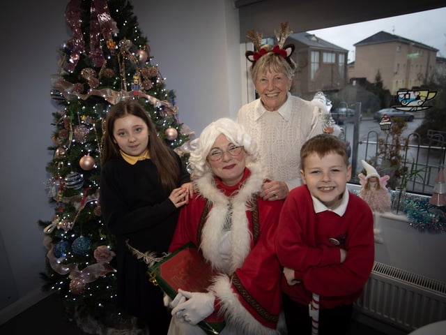 Mrs. Claus pictured with Jeanette and some of the children who helped out with the Annual Senior Citizens Christmas Party.