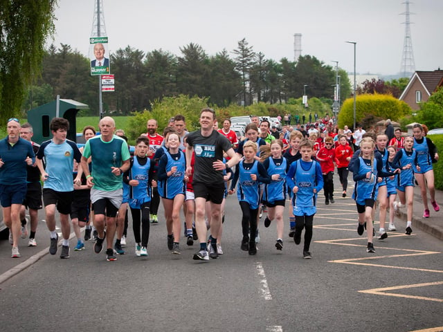 Andy McDermott, parents, governors and the cross-country team make their way to the finish line during Friday’s run.
