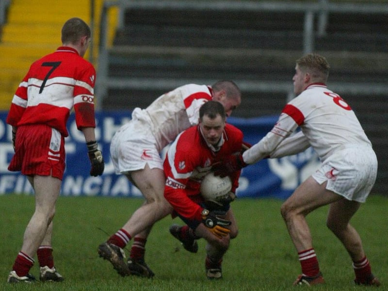 Derry's Kevin McCloy break the tackle of two Tyrone players during the 2004 McKenna Cup meeting in Healy Park.