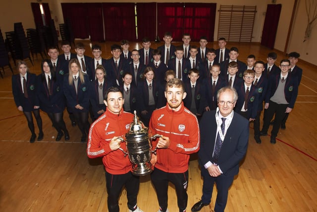 Duo Ciaran Coll and Jamie McGonigle and Mr. Harkin pictured with the trophy and a selection of the Derry City supporters at Oakgrove College.