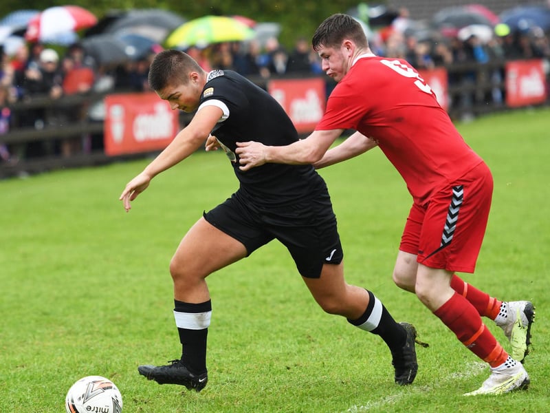 Maiden City's Connor Moore powers past Carndonagh Under-19's player Kyran Cantwell.
