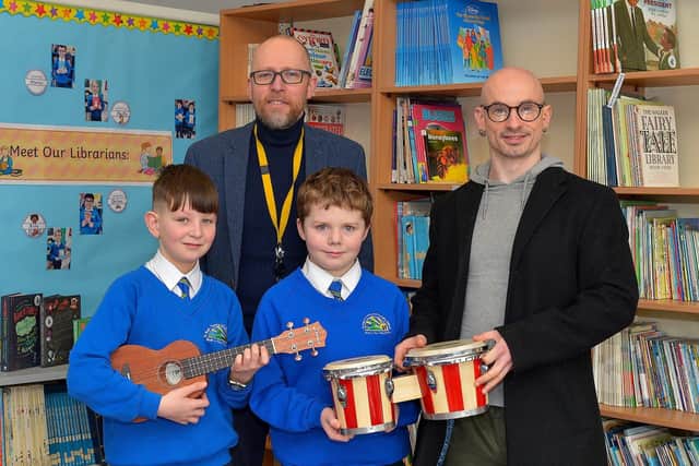 Principal Gareth Blackery, and Eamonn McCarron, from Project Sparks, pictured with P7 pupils Valan and James with some of the musical instruments donated to St Paul’s Primary School, Slievemore on Tuesday last. Photo: George Sweeney. DER2310GS – 011