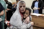 An injured Palestinian woman covered in dust and blood hugs an injured girl child at the hospital following the Israeli bombardment of Khan Yunis in the southern Gaza Strip on November 15, 2023. More than 11,000 people have been killed in relentless Israeli bombardment of the Gaza Strip, according to the health ministry. (Photo by Belal KHALED / AFP) (Photo by BELAL KHALED/AFP via Getty Images)
