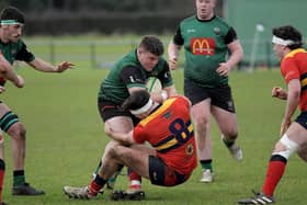 City of Derry’s Adam Marley is hauled to the ground by Ballyclare’s Jack Gamble while Fearghus Canning looks on in last week's league encounter. Photo: George Sweeney