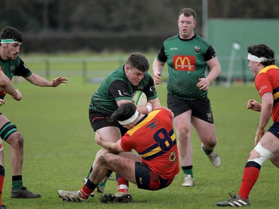 City of Derry’s Adam Marley is hauled to the ground by Ballyclare’s Jack Gamble while Fearghus Canning looks on in last week's league encounter. Photo: George Sweeney