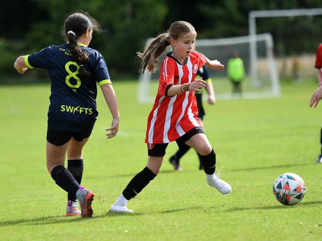 Tristar's Clara O'Doherty skips past Sion Swifts player Eve Connolly during their Girls Under-11 match at Wilton Park.