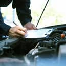 A mechanic examining a car.