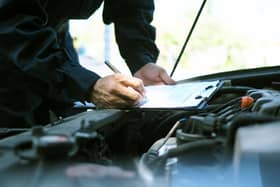 A mechanic examining a car.