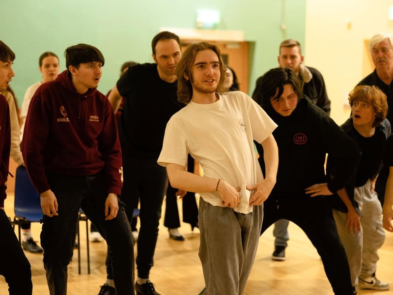 Aidan McLaughlin as Will Parker with members of the ensemble of Oklahoma.