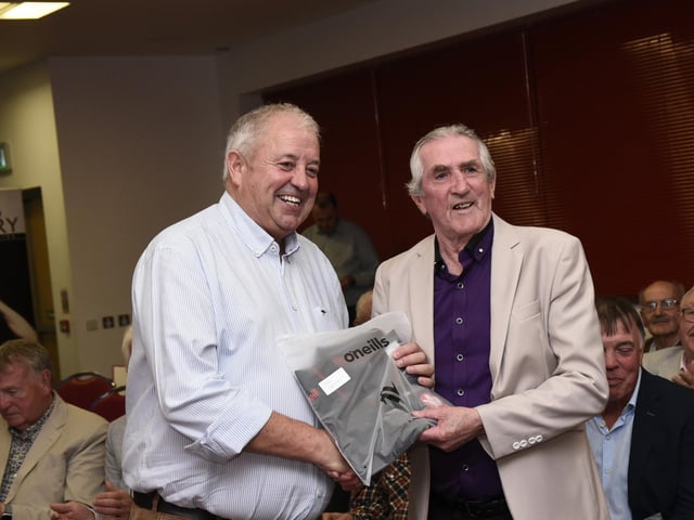 Derry County Chairman John Keenan makes a presentation to Peter Stevenson at the Ulster SFC Winners' reunion in Owenbeg on Friday.