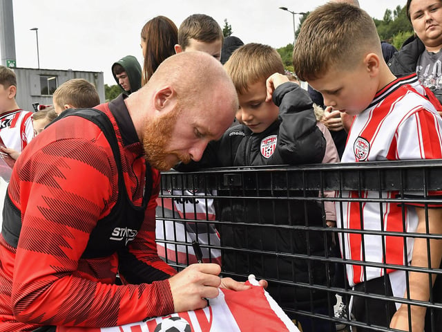 Liam Boyce signs a flag for fans at the Derry City open training session on Monday morning in  Brandywell Stadium. The event was organised at part of the Gasyard Feile.  Photo: George Sweeney / Derry Journal