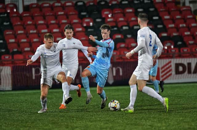 Ballinamallard players close in on Institute's Michael Harris during Friday evening's game at the Brandywell. Photo: George Sweeney