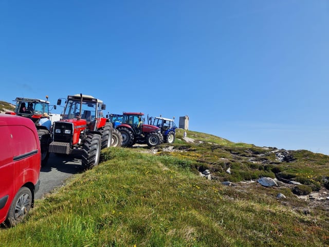 Tractors gathering under blue skies.