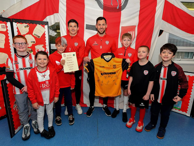 Derry City’s Ciaran Coll and Pat Hoban present Gaelscoil Eadain Mhoir with a signed shirt during their visit to the school and received a collection of poems composed by Rang 7 pupils . Photo: George Sweeney