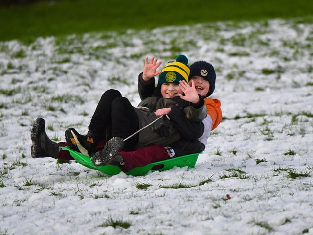 Children enjoy a day off school and a slide in the snow in Brooke Park on Thursday afternoon. Photo: George Sweeney