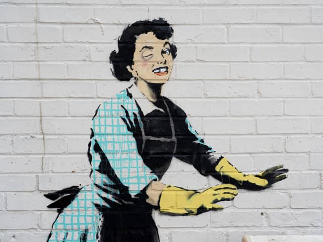 Undated handout file photo of one of the new works by Banksy, appears to show a 1950's housewife, wearing a classic blue pinny and yellow washing up gloves, with a swollen eye and a missing tooth seemingly shoving her male partner into a chest freezer, the piece is set on a white wall backdrop in Kent. Issue date: Tuesday February 14, 2023.