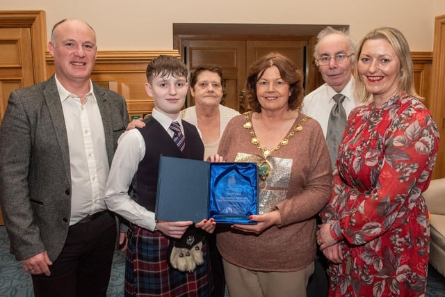 Twelve years old Jacob Laird from Bready Ulster Scots Pipe Band has been recognised by the Mayor Councillor Patricia Logue after he was crowned Ulster, All Ireland and World Champion solo snare drum champion. Pictured with Jacob are his mum and dad, Tanya and Ivor and grand parents Ann and Kenneth Scott. Picture Martin McKeown. 11.12.23