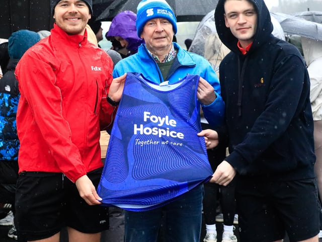 Noel McGilloway makes a presentation of a Foyle Hospice T-shirt to Emmett McGilloway and Gavin Doherty, at the start of the run/walk in memory of Ding Doherty. (Photo - Tom Heaney, nwpresspics)