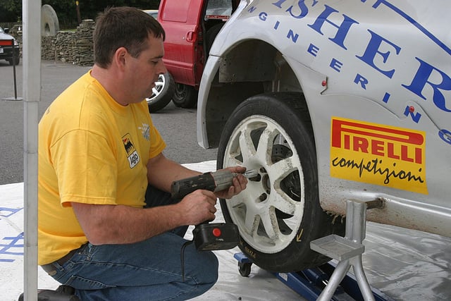 Gerry Jennings demonstrating the art of a quick wheel change at the start of the third stage of the Lark in the Park Rally.