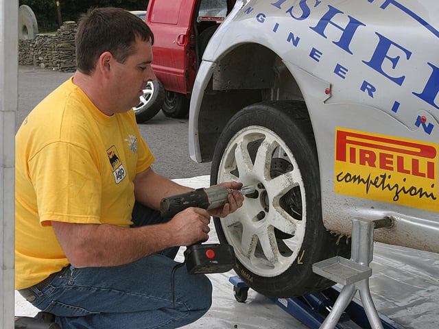 Gerry Jennings demonstrating the art of a quick wheel change at the start of the third stage of the Lark in the Park Rally.