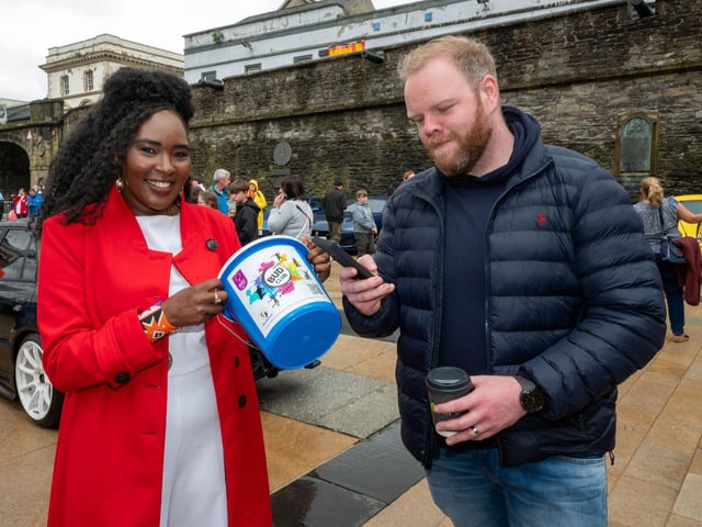 David Qinn donates using gis phone and a QR code as Derry City and Strabane District Council Mayor, Councillor Lilian Seenoi-Barr hosted Supercar Saturday in Guildhall Square to raise money for the Mayoral Charity Bud Club. The event attracted car enthusiasts and owners from across the region to support aid the local charity. Picture Martin McKeown. 24.05.25