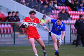 Derry’s Danny McDermott holds off a tackle from Oliver McCrystal of Cavan. Photo: George Sweeney