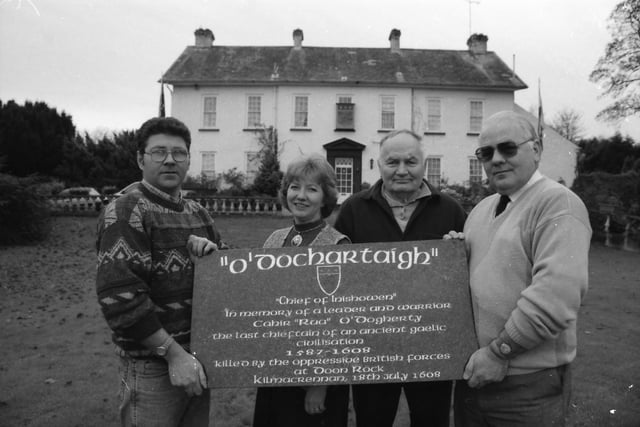 Vincent 'Corney' Doherty, Tullydish, on left, presenting a memorial to Conchobar O'Dochartaigh of the Sheriff's Mountain Dohertys, on right, with Kathleen Daugherty Barr, Moville, and Patrick O'Dougherty.
