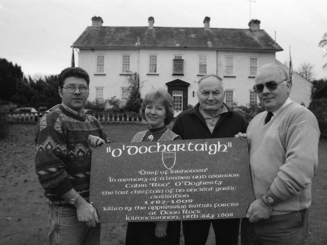 Vincent 'Corney' Doherty, Tullydish, on left, presenting a memorial to Conchobar O'Dochartaigh of the Sheriff's Mountain Dohertys, on right, with Kathleen Daugherty Barr, Moville, and Patrick O'Dougherty.