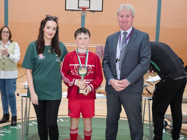 Jay Gallagher, captain of St. Anne's Primary School, winners of the 2024 Sean O'Kane Perpetual Primary Schools' Cup, receives the trophy from Sean's sister, Collene O'Kane, and Mr Paul Kealey, Vice-Principal, St. Joseph's Boys'. (Photo: Jim McCafferty Photography)