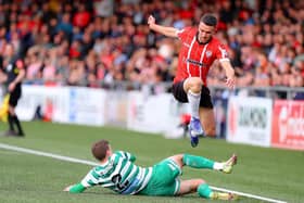 Mickey Duffy hurdles Sean Gannon during Derry City's clash with Shamrock Rovers. Colum Eastwood wants the Executive to overcome obstacles to the redevelopment of the Brandywell.