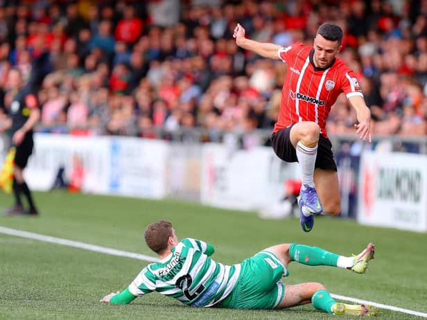 Mickey Duffy hurdles Sean Gannon during Derry City's clash with Shamrock Rovers. Colum Eastwood wants the Executive to overcome obstacles to the redevelopment of the Brandywell.