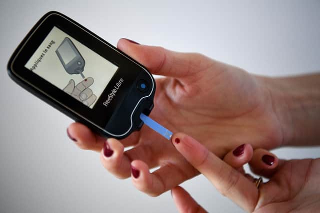 A woman with diabetes uses a glucometer to measure the glycemia in her blood. (Photo by FRANCK FIFE/AFP via Getty Images)
