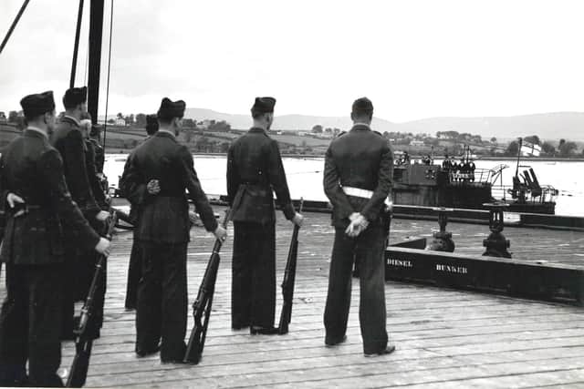 US Marines formed part of Adm. Horton’s guard of honour, as they watched a U-boat, flying the white ensign in place of the swastika, make for its berth on May 14, 1945