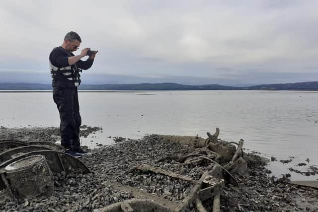 Jonny McNee, DAERA Marine Plan team, photographing the rotor and rotor blades of the discovered Royal Navy Dragonfly helicopter.