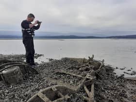 Jonny McNee, DAERA Marine Plan team, photographing the rotor and rotor blades of the discovered Royal Navy Dragonfly helicopter.