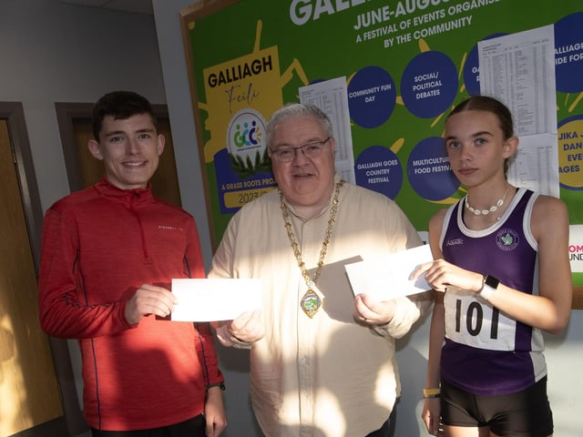 JUVENILE WINNERS. . . The Deputy Mayor, Darren Guy presenting the Galliagh Feile 5k U-18 winners Aidan Healy and Aara Doran with their prizes on Friday night. (Photos: Jim McCafferty Photography)