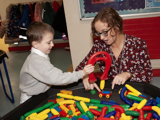 Tiernan shows Mrs. McLaughlin his creation during P1 play at Sacred Heart PS.