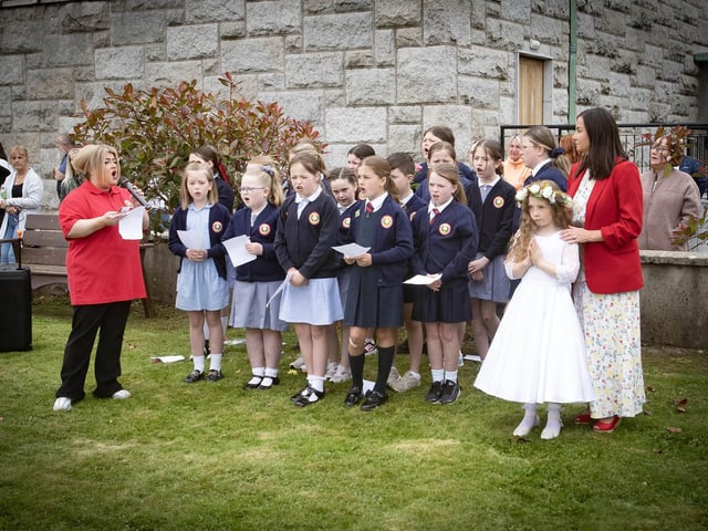 The Holy Child Primary School Choir performing under the leadership of Mrs. Aine McCabe. On right is Flowergirl Matilda Condren and Mrs. Pat Concannon, Principal.