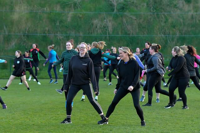 Warm-up exercises ahead of Doire Trasna’s first Mothers and Others football practice session, at Corrody Road. Photo: George Sweeney.  DER2316GS – 09