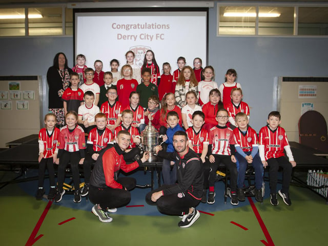 Derry players Caoimhin Porter and Michael Duffy and the FAI Cup pictured with the P5 classes at Greenhaw PS.