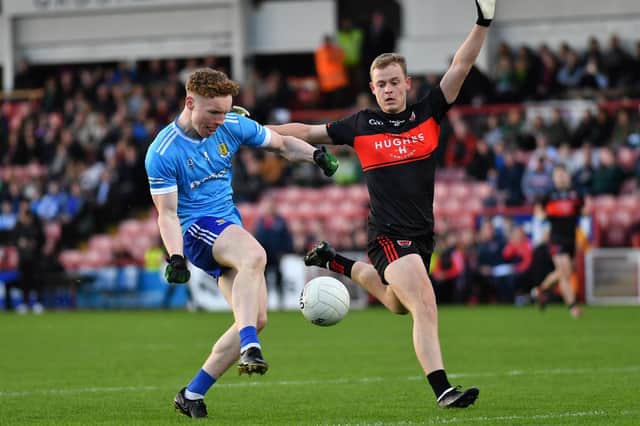 Niall O’Donnell of Ballinderry gets off a shot as Carrickcruppen’s Oisin O’Hare closes in. Photo: George Sweeney