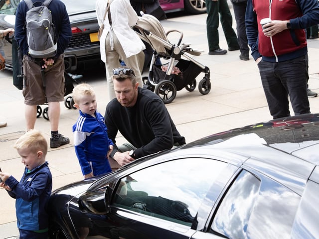 CAN I HAVE ONE OF THOSE DADDY?. . . . .This youngster has eyes only for this sports car during Saturday's event.
