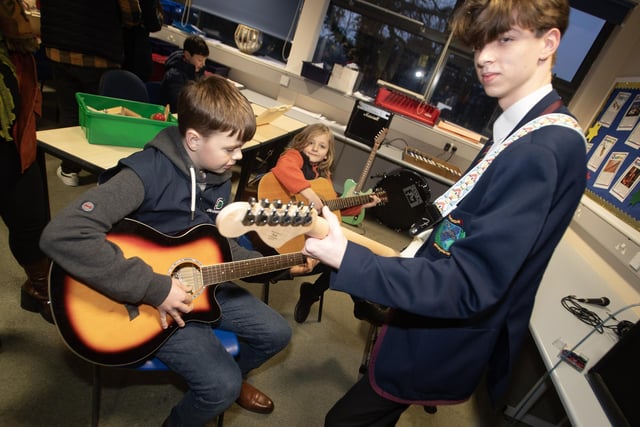 Year 11 student Stephen Crawford showing some guitar chords to some of the prospective pupils from visiting schools.