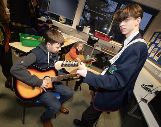 Year 11 student Stephen Crawford showing some guitar chords to some of the prospective pupils from visiting schools.